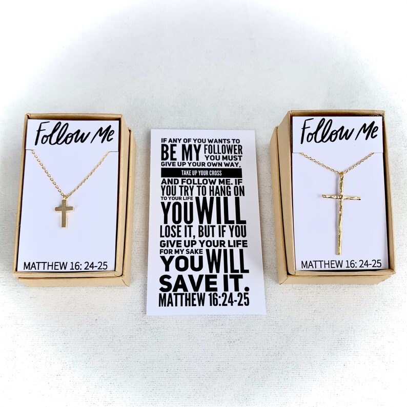 May include: Two boxes with gold cross necklaces inside. The boxes are brown and have the words "Follow Me" and "Matthew 16:24-25" printed on them. The card in the middle has a quote from the Bible: "If any of you wants to be my follower give up your own way, take up your cross and follow me. If you try to hang on to your life you will lose it, but if you give up your life for my sake you will save it. Matthew 16:24-25"