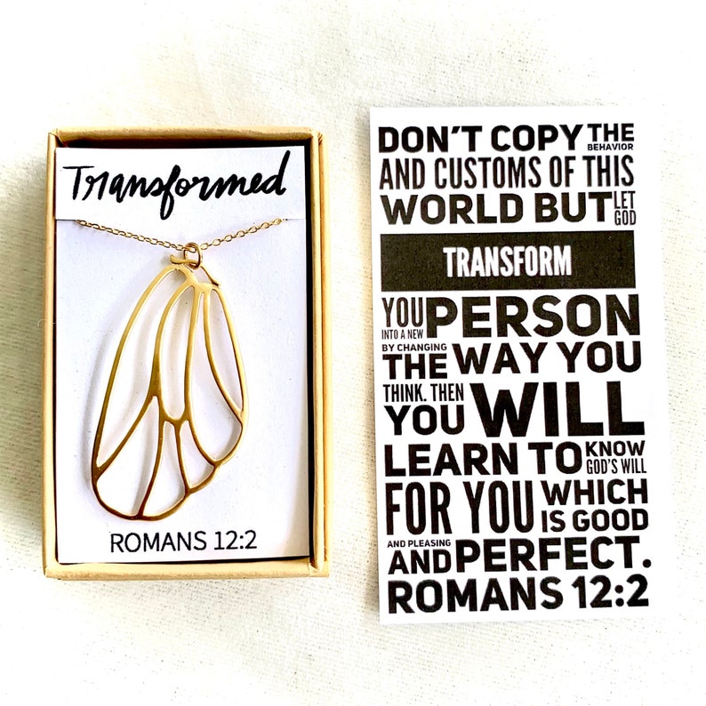 May include: Gold necklace with a butterfly wing pendant and a small box with the words "Transformed" and "Romans 12:2". A card with the text "Don't copy the behavior and customs of this world but let God transform you person the way you think. Then you will learn to know God's will for you which is good and pleasing and perfect. Romans 12:2" is also shown.