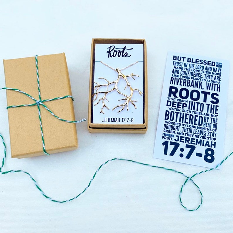 May include: A gold-tone necklace with a tree branch design, packaged in a small box with the words "Roots" and "Jeremiah 17:7-8". A card with the same text and the words "But Blessed are those who trust in the Lord and have made the Lord their hope and confidence. They are like trees planted along a riverbank, with roots that reach deep into the water. Such trees are not bothered by the heat or drought. Their leaves stay green, and they never stop producing fruit. Jeremiah 17:7-8" is also included.