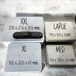 May include: Four white metal tins with black text. The tins are labeled with sizes: XXL, XL, LARGE, and MED. The tins are arranged in a grid pattern. The text on the tins includes the size and the dimensions in inches.  XXL: 210 x 210 x 11.5 mm, XL: 165 x 200 x 61 mm, LARGE: 195 x 155 x 15 mm, MED: 110 x 130 x 55 mm.