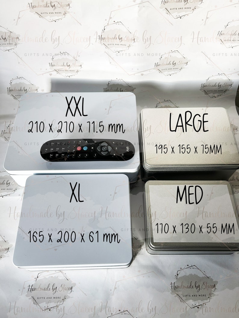 May include: Four white metal tins with black text. The tins are labeled with sizes: XXL, XL, LARGE, and MED. The tins are arranged in a grid pattern. The text on the tins includes the size and the dimensions in inches.  XXL: 210 x 210 x 11.5 mm, XL: 165 x 200 x 61 mm, LARGE: 195 x 155 x 15 mm, MED: 110 x 130 x 55 mm.