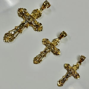 Puede incluir: Tres crucifijos dorados con dise&ntilde;os intrincados. Los crucifijos presentan una figura de Jesucristo en la cruz.