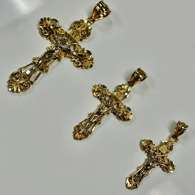Puede incluir: Tres crucifijos dorados con dise&ntilde;os intrincados. Los crucifijos presentan una figura de Jesucristo en la cruz.