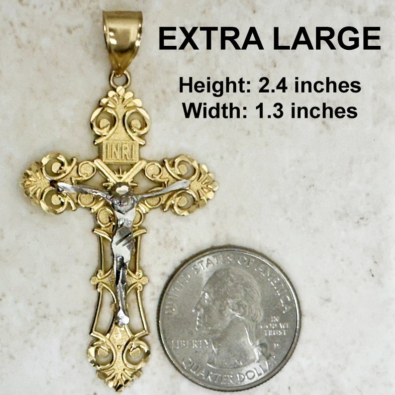 Puede incluir: Un colgante de cruz de dos tonos, dorado y plateado, con detalles intrincados. El colgante mide 2,4 pulgadas de alto y 1,3 pulgadas de ancho. El colgante presenta una representaci&oacute;n de Jesucristo en la cruz. El colgante se muestra junto a una moneda de veinticinco centavos de d&oacute;lar estadounidense para comparar el tama&ntilde;o.