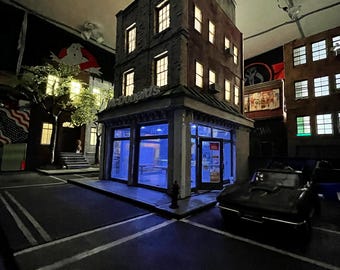 May include: A miniature cityscape at night with a black car parked in front of a building with a lit sign that says "McDonald's".