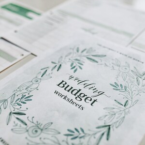May include: A white sheet of paper with a green floral border and the text "wedding Budget worksheets".