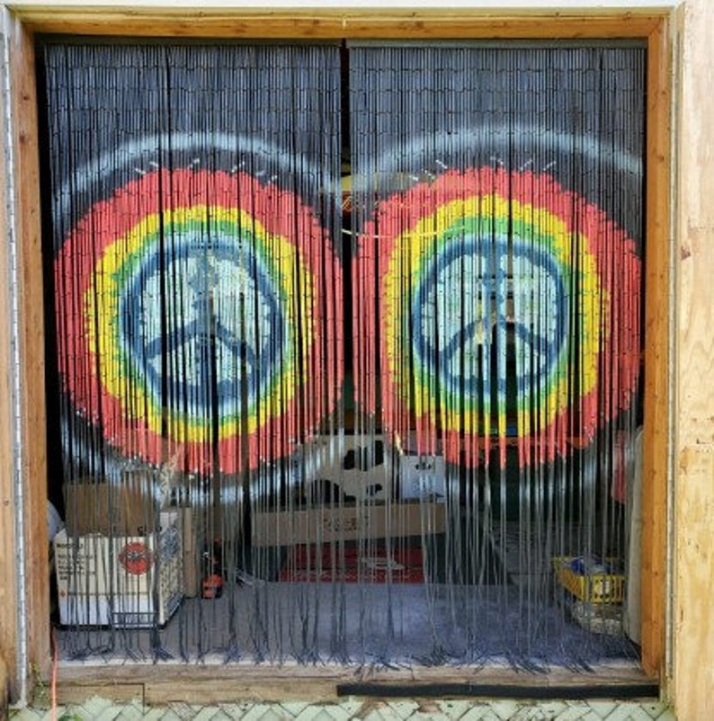 May include: Black bamboo beaded curtain with two colorful peace sign designs. The peace signs are painted in a rainbow of colors, with a blue peace symbol in the center.