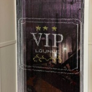 May include: Black beaded door curtain with a white VIP LOUNGE sign. The sign has three gold stars and a decorative design. The curtain hangs in a doorway, with a glimpse of the interior visible through the beads.