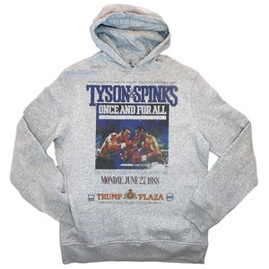 May include: Gray hooded sweatshirt with a vintage-style print of the Tyson vs. Spinks boxing match. The print features the text "Tyson vs. Spinks Once and For All" and a photo of the two boxers in the ring. The text "Monday, June 27, 1988" is also included in the print.