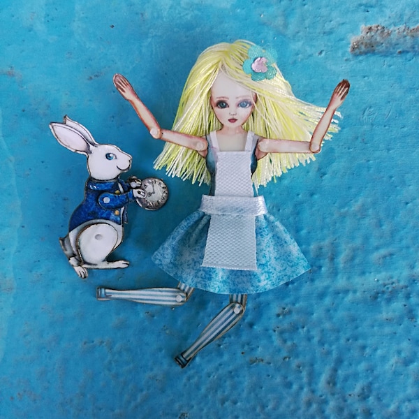 Alice au pays des merveilles avec lapin blanc. Ils ont une épingle au dos et sont articulés, une marionnette en papier, de l’art original qui peut être un bijou.