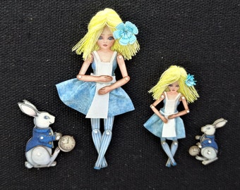 Alice in wonderland with white rabbit. They have a pin on the back and are articuladed, a paper puppet, original art that can be a jewel.