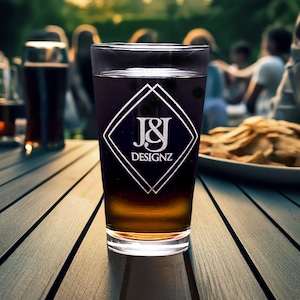 Personalized 16 oz pint glass with elegant logo, with a social gathering in the background, perfect for custom engraved gifts or promotional items