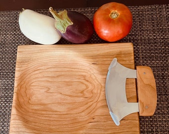 Peut inclure: Une planche à découper en bois avec un couteau incurvé intégré. La planche a un grain de bois naturel et est parfaite pour servir du fromage, des fruits ou d'autres amuse-gueules. Le couteau est en acier inoxydable et a un manche en bois.