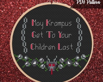 May include: A black cross-stitch hoop with the text "May Krampus Get To Your Children Last" in white and red. The design includes a chain border and a floral and monster motif at the bottom. The background is a glittery red.