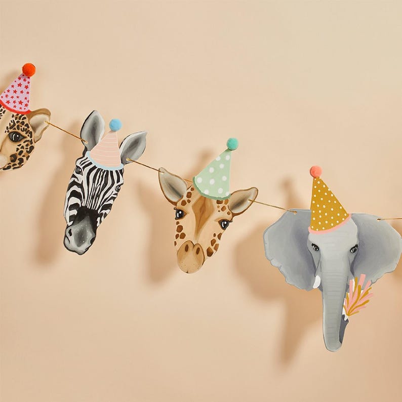 May include: A garland of animal heads, including a giraffe, zebra, and elephant, each wearing a party hat. The heads are painted in soft colors and strung on a thin gold string, perfect for a children's birthday party.