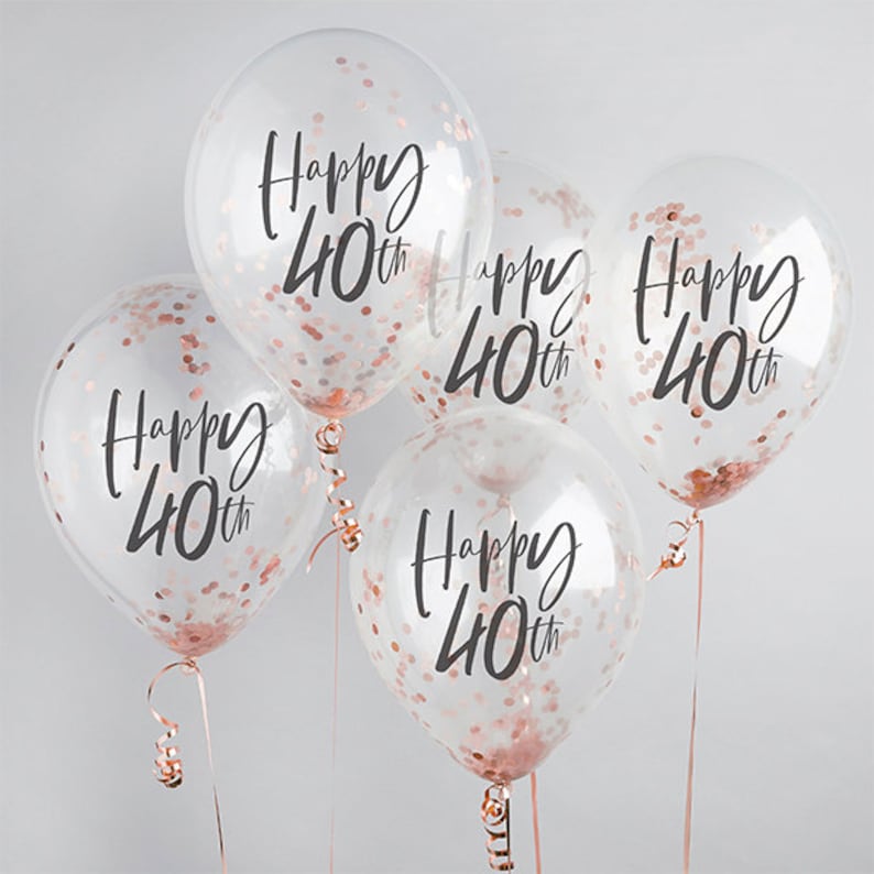May include: Five clear balloons filled with rose gold confetti. Each balloon has the words "Happy 40th" printed in black script. The balloons are tied with rose gold ribbons, perfect for a 40th birthday celebration.