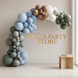 May include: An arch made of balloons in shades of light blue, brown, white, and sage green. The text FIESTA PARTY STORE is centred in gold lettering. A small wooden table sits to the right of the balloon arch against a plain wall.