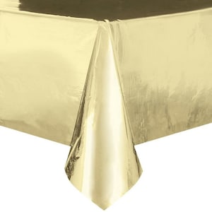 May include: A gold plastic tablecloth. The tablecloth is shiny and has a metallic finish.