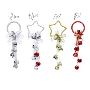 May include: Four Christmas decorations in silver, white, gold, and red. Each has a loop, a bow, and dangling bells. The silver decoration has silver bells, the white has red and white bells, the gold has gold bells, and the red has red bells.