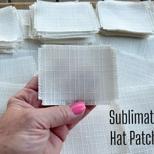May include: A pile of white sublimation hat patches. The patches are square and have a textured surface. The text "Sublimation Hat Patches" is visible in the image.