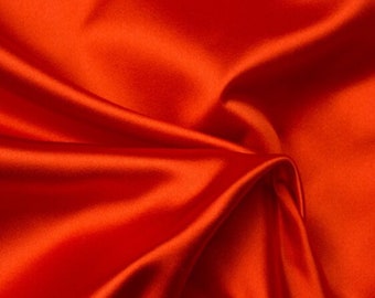 May include: Close-up of vibrant orange satin fabric with soft folds and highlights. The fabric has a smooth, luxurious texture, reflecting light and creating a dynamic visual effect. Ideal for apparel, home decor, or craft projects.