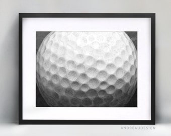 Op de afbeelding: Een zwart-witfoto van een golfbal. De afbeelding is een close-up van de bal, waarbij de putjes in detail worden getoond.