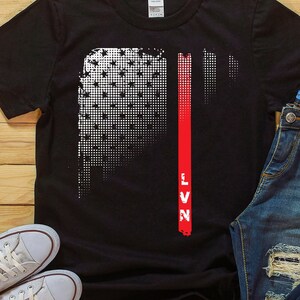May include: Black t-shirt with a white and red graphic of a distressed American flag with the word "LVN" in red.