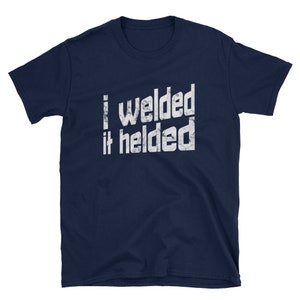 May include: Navy blue t-shirt with a white distressed graphic that reads "I welded it helded".