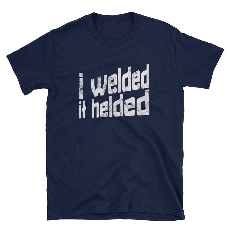 May include: Navy blue t-shirt with a white distressed graphic that reads "I welded it helded".