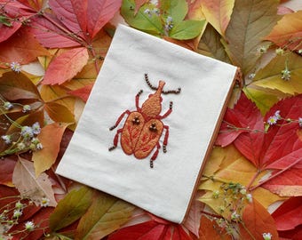 手刺繍の甲虫モチーフの化粧ポーチ。甲虫好き、昆虫愛好家、昆虫学者、自然愛好家への贈り物に最適です。