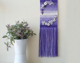 Purple woven wall hanging with with embroidered flowers. Narrow, long, vertical woven art. Gallery wall decoration. Flower embroidery art.