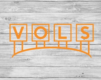 May include: Orange block letters spelling "VOLS" on a white wood background.