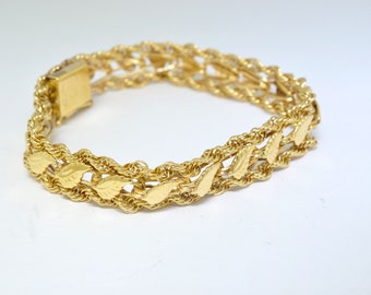 May include: A gold bracelet with a rope chain design and leaf-shaped links.