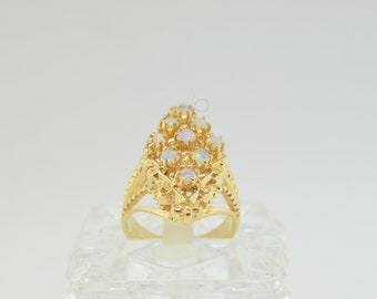 May include: A gold ring with a cluster of white opals set in a delicate, intricate design.