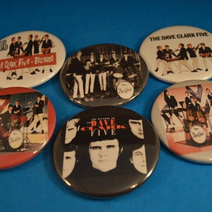May include: Six round buttons with images of the band The Dave Clark Five. The buttons feature different album covers and band photos. The buttons are white, gray, red, and black.