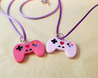 VIDEO GAME CONTROLLERS Set of 2 Charms Pendant Necklaces. Lavender charm on purple rope style necklace; hot pink charm on purple necklace.