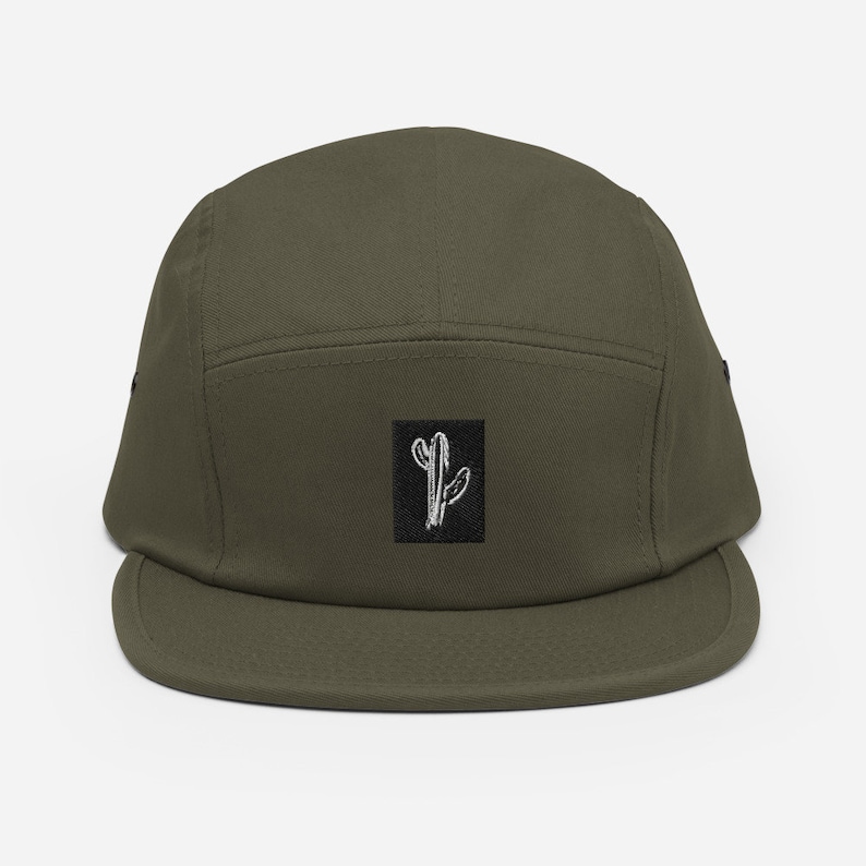 May include: A green 5-panel cap with a black square patch featuring a white embroidered cactus design.