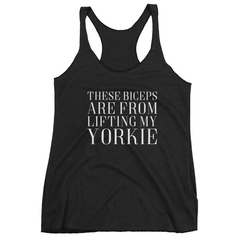 May include: Black racerback tank top with white text that reads "These biceps are from lifting my yorkie".