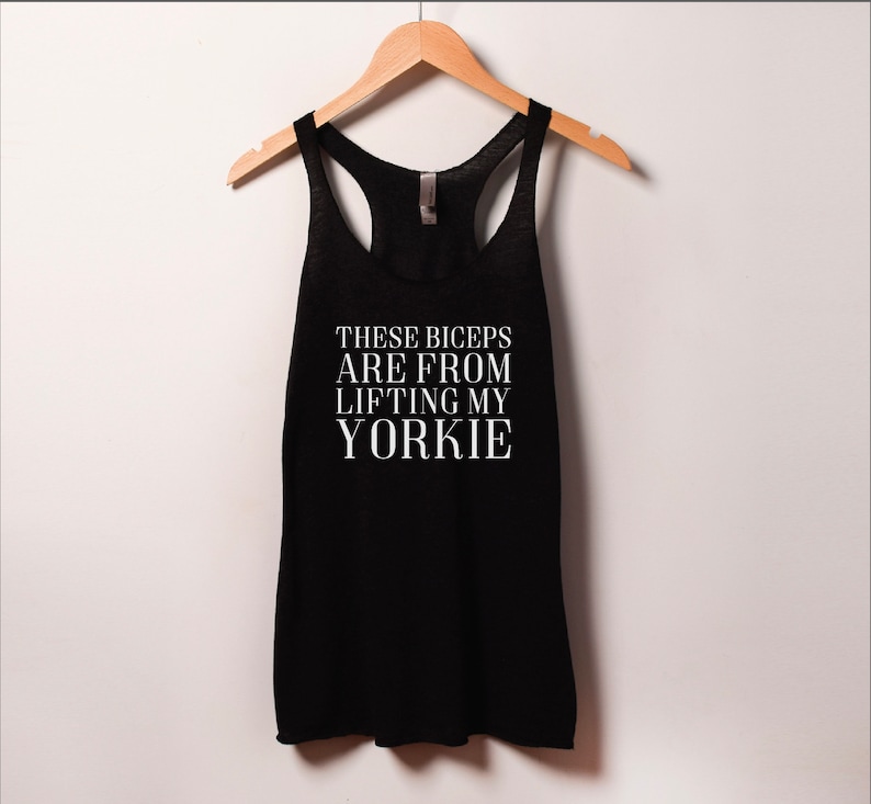 May include: Black tank top with white text that reads "These biceps are from lifting my yorkie".