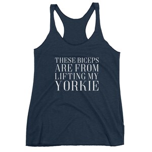 May include: A navy blue tank top with the text "These biceps are from lifting my yorkie" in white.
