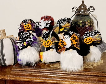 May include: A group of nine Halloween gnomes with black and white striped hats, black and white checkered hats, and black hats with orange and black bows. The gnomes have white beards and are decorated with pumpkins, ghosts, and bats.