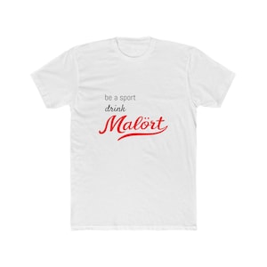 May include: White t-shirt featuring the text "be a sport drink Malört" in black and red. The word "Malört" is in a cursive font. The shirt is made of a soft, comfortable material.