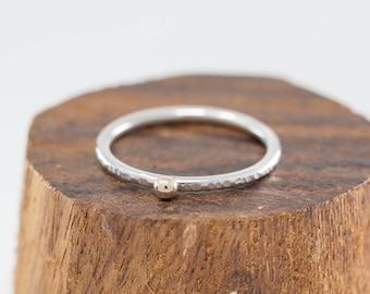 Peut inclure: Une bague en argent martelée avec un petit accent de perle dorée.