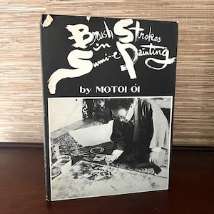 May include: A black and white book titled "Brush Strokes in Sumi-e Painting" by Motoi Oi. The cover features a black and white photo of a person painting with a brush.