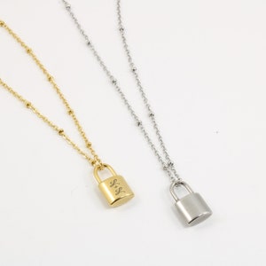 Peut inclure: Deux colliers en or avec un pendentif en forme de cadenas. Le cadenas du collier de gauche porte l'inscription "L+S".
