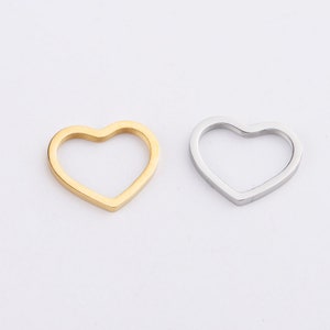 Pu&ograve; includere: Due ciondoli in metallo a forma di cuore, uno dorato e uno argentato. I ciondoli sono vuoti e hanno una finitura liscia e lucida.