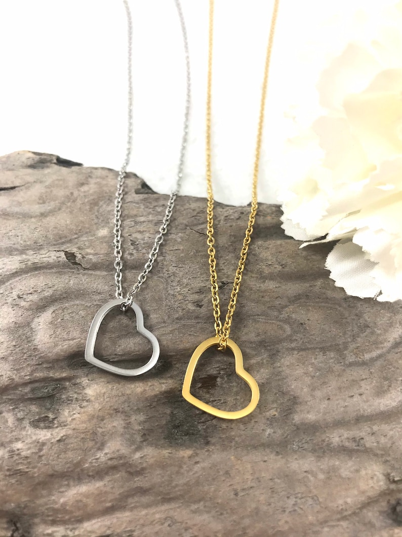 Pu&ograve; includere: Due delicate collane con ciondoli a forma di cuore aperto. Una collana &egrave; d'argento e l'altra &egrave; d'oro.