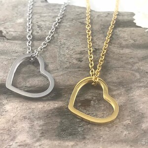 Pu&ograve; includere: Due collane d'argento con ciondoli a forma di cuore aperto. Una collana ha un ciondolo a forma di cuore d'argento e l'altra ha un ciondolo a forma di cuore d'oro.