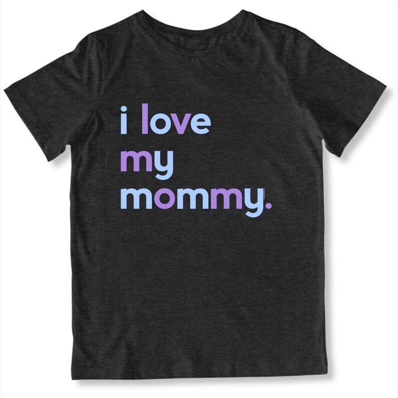 May include: Dark gray t-shirt with the phrase "i love my mommy" printed in light blue, purple, and lavender. The shirt is a crew neck and has short sleeves.