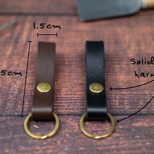 Slim Italian leather loop keyrings/keychains in dark brown and black side by side with solid brass split ring and rivet. Measurements 7.5cm by 1.5cm wide